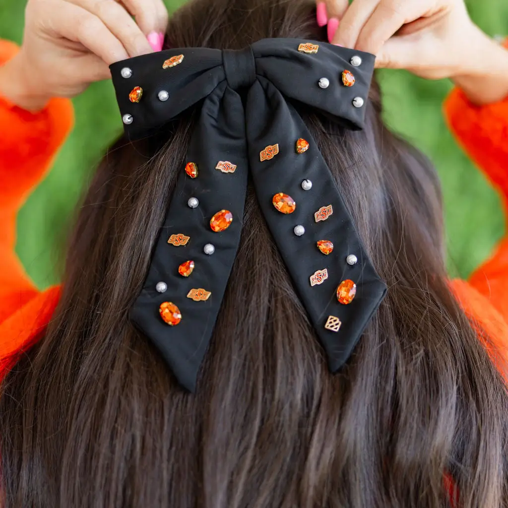 Black bow barrette with gold University of Arkansas logo charms and hand-sewn resin pearls.