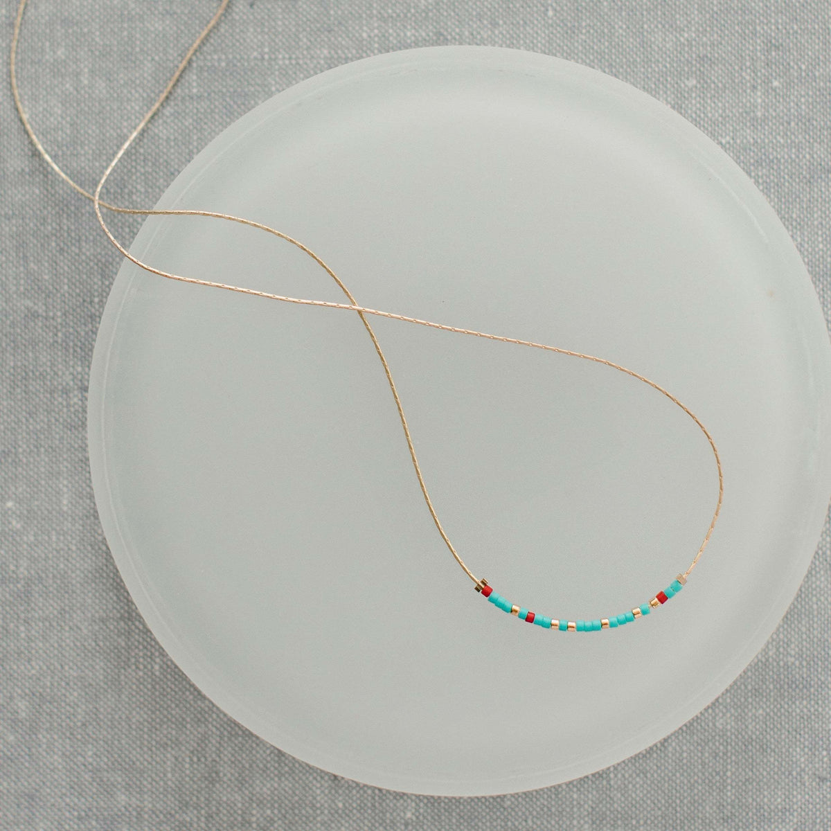Turquoise and red glass bead necklace with Morse code message pendant on a 16.5-inch chain.