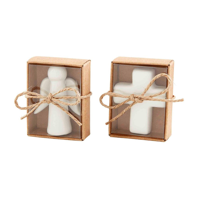 Two small brown gift boxes tied with twine, containing a white ceramic angel and a white cross.