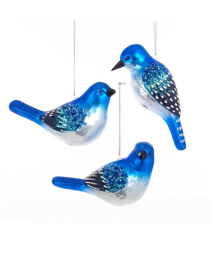 Glass blue bird ornament with black and white painted wings featuring blue glitter accents.