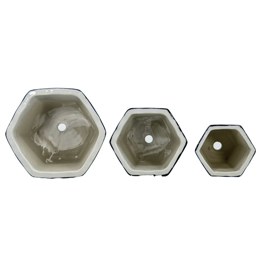 Blue and white hexagonal ceramic plant pot with floral pattern and ruffled lip edge