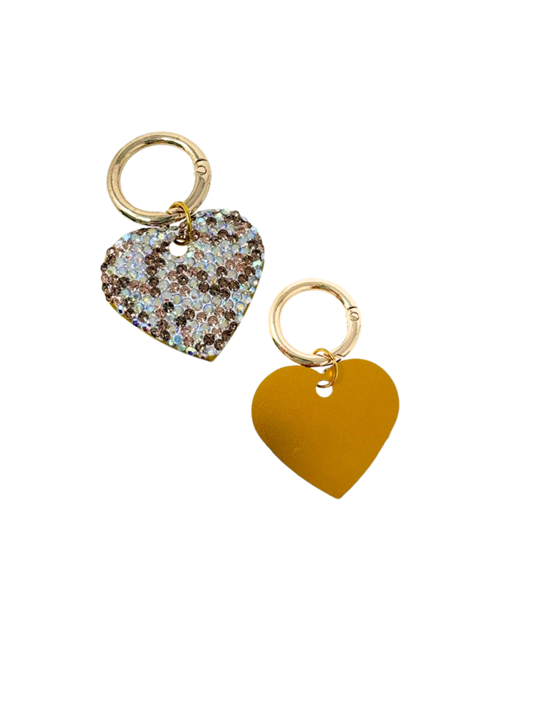 Two heart-shaped dog tags with gold clasps, one with sparkling rhinestones and one in solid yellow.