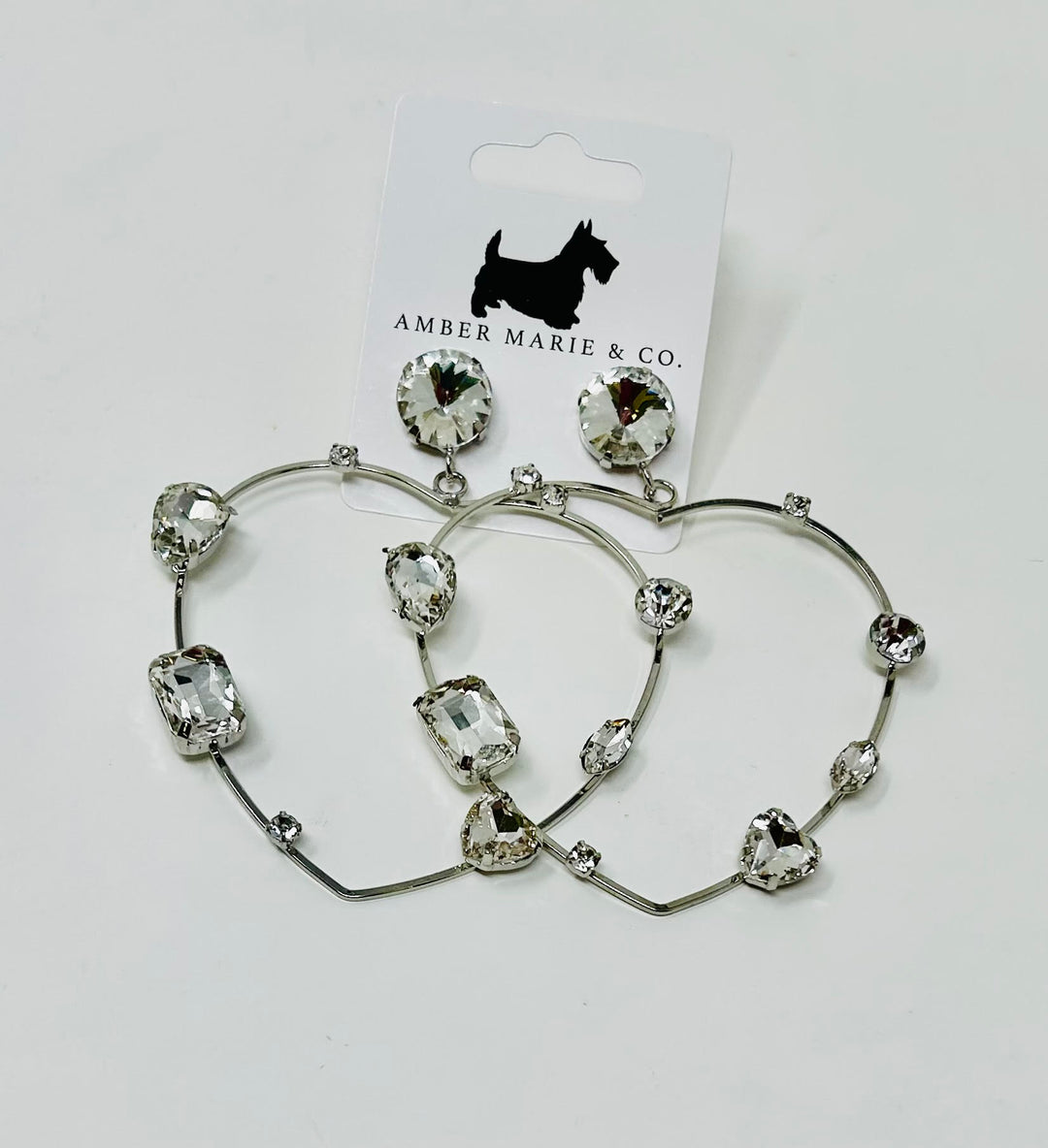Heart-shaped earrings featuring white crystals set in a silver-tone metal frame.