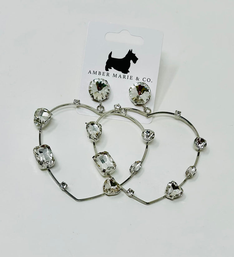 Heart-shaped earrings featuring white crystals set in a silver-tone metal frame.