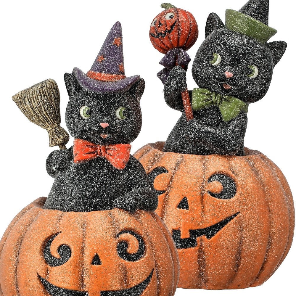 Two paper pulp black cat figurines in jack-o'-lanterns with a sugared finish and festive hats.