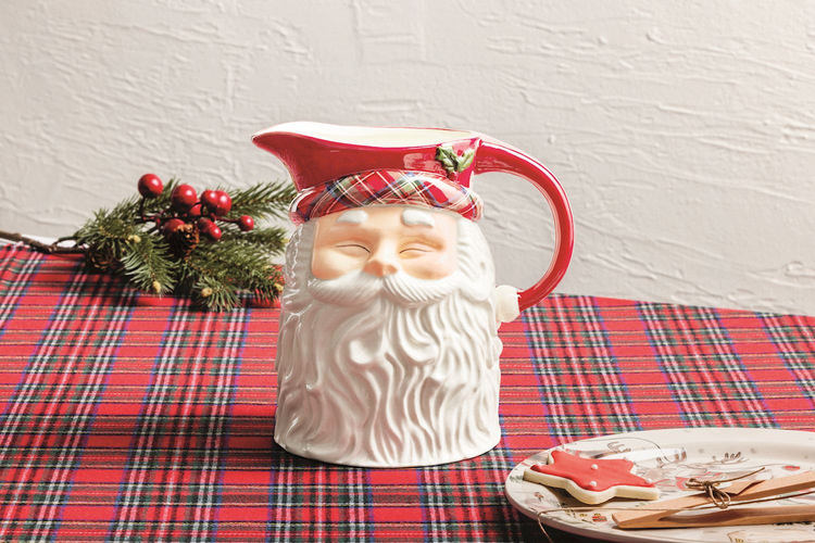 Ceramic Santa Claus pitcher with a red tartan hat and white beard on a red plaid tablecloth.