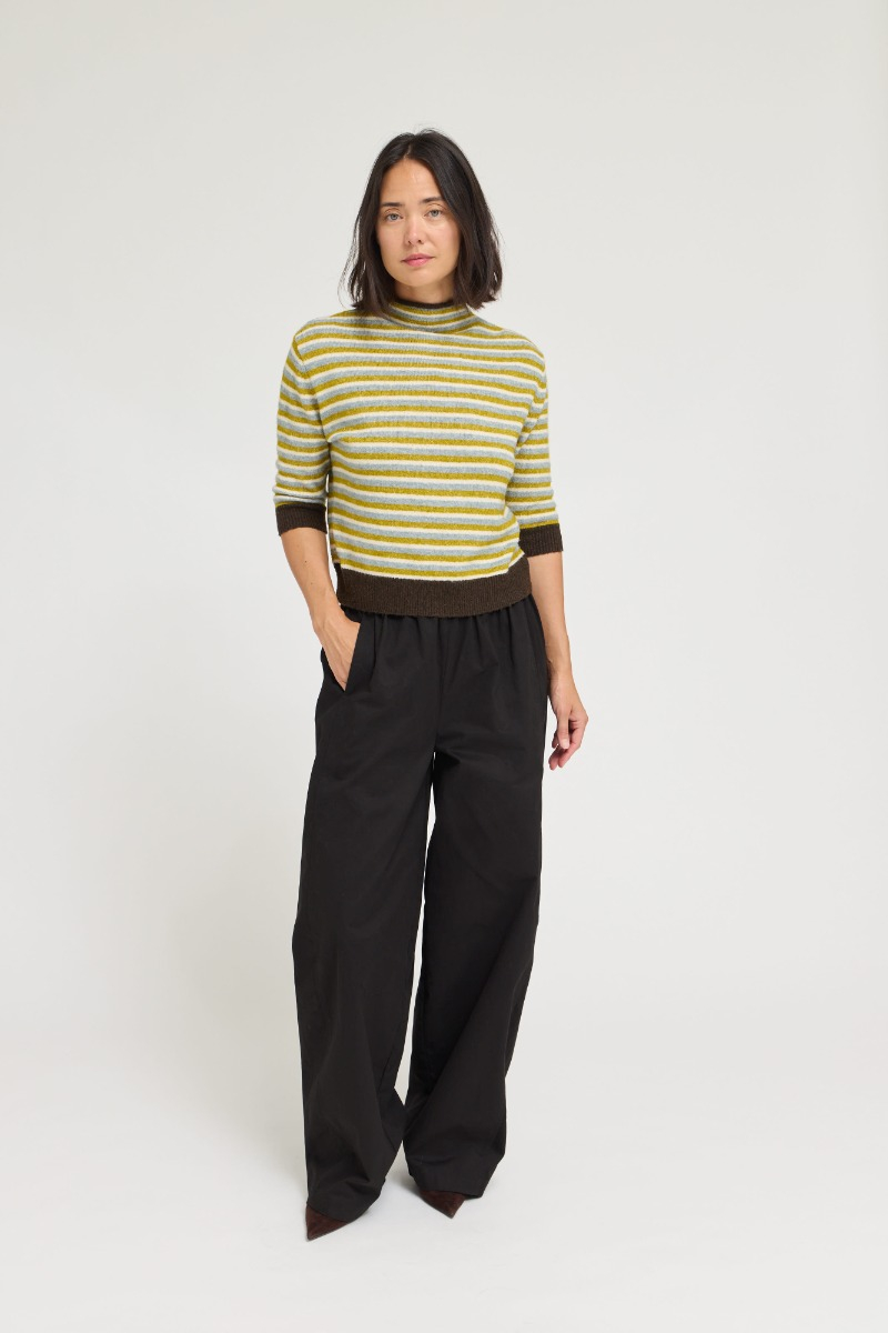 Woman wearing the Patricia 7/8 Sleeves Stripe Sweater Top with black wide-leg trousers.