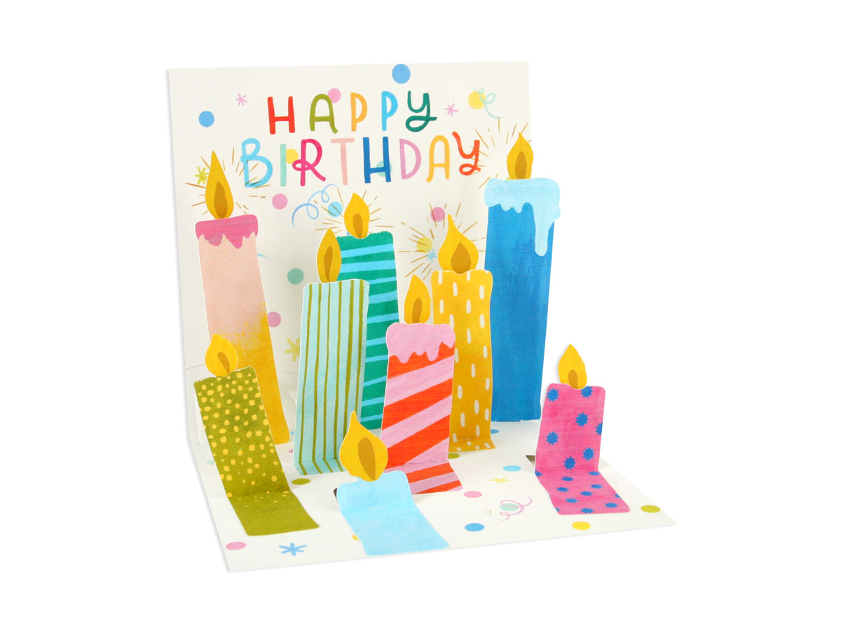 Pop-up birthday card featuring colorful illustrated candles and 'Happy Birthday' in playful text.