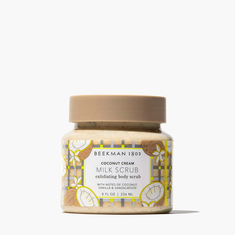 Coconut cream body scrub in a jar with gentle jojoba beads visible