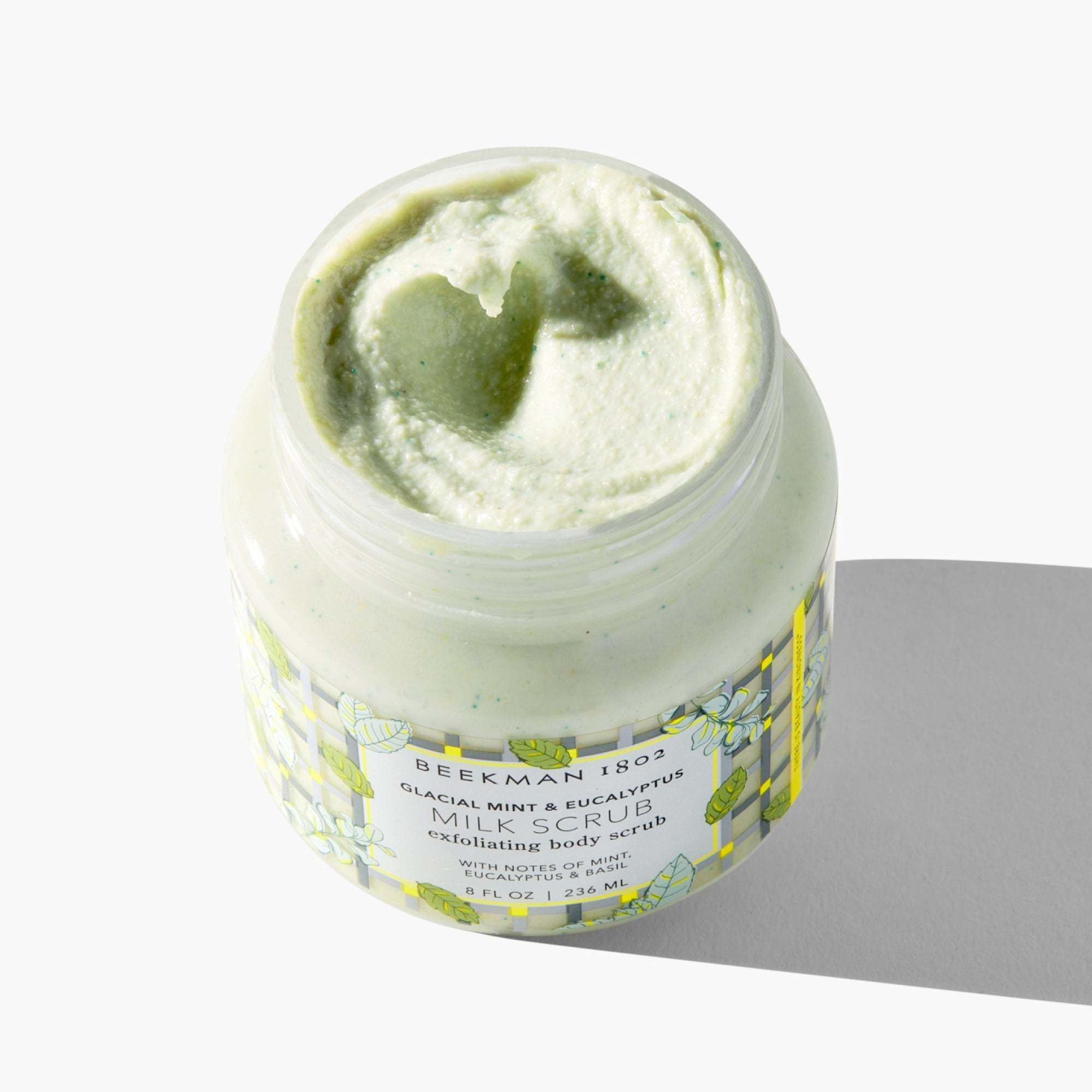 White jar of Body Scrub with oat milk ingredients visible on label