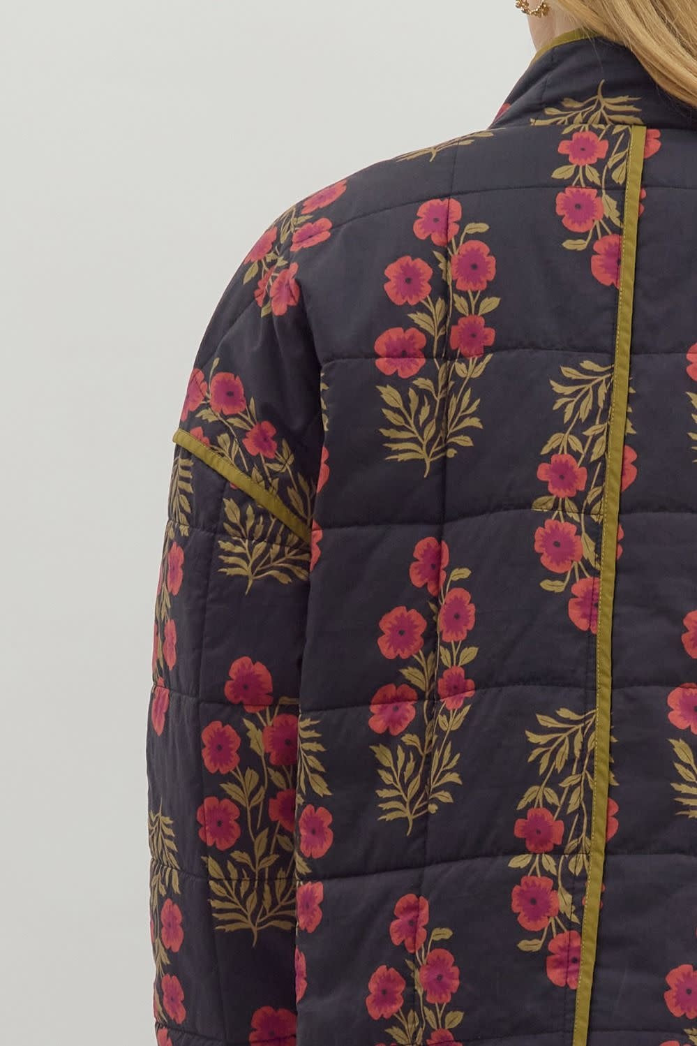 Black botanical quilted jacket with contrast binding and front patch pockets.