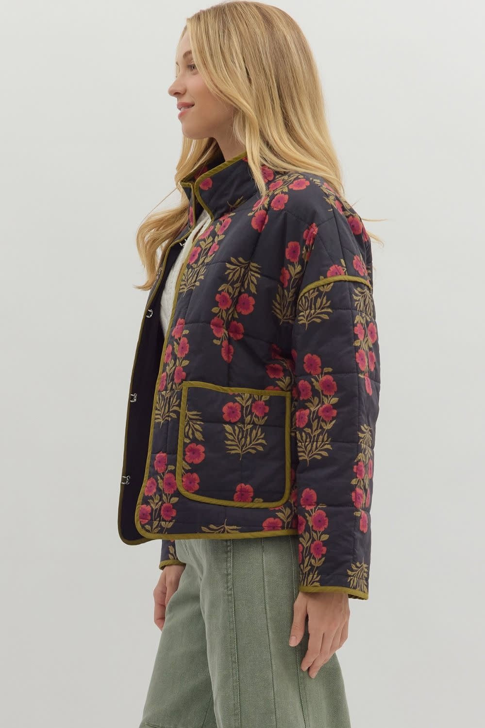 Side view of black botanical quilted jacket with contrast binding.