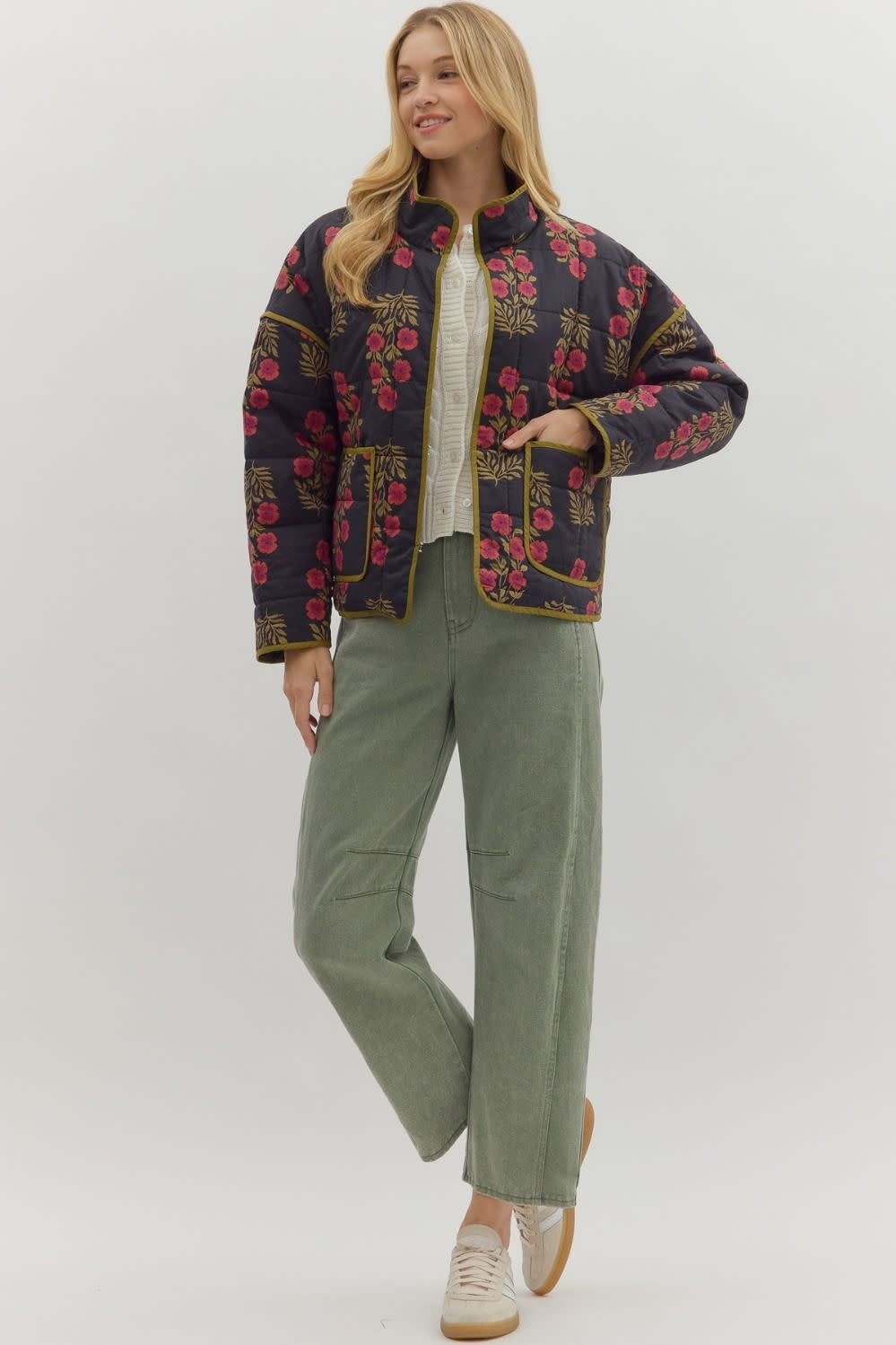 Black quilted botanical long-sleeve jacket with contrast binding and front patch pockets.