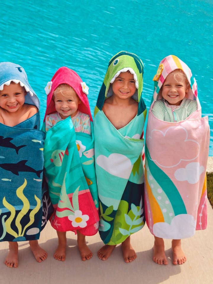 Soft cotton velour hooded beach towel in beige with subtle textured pattern.