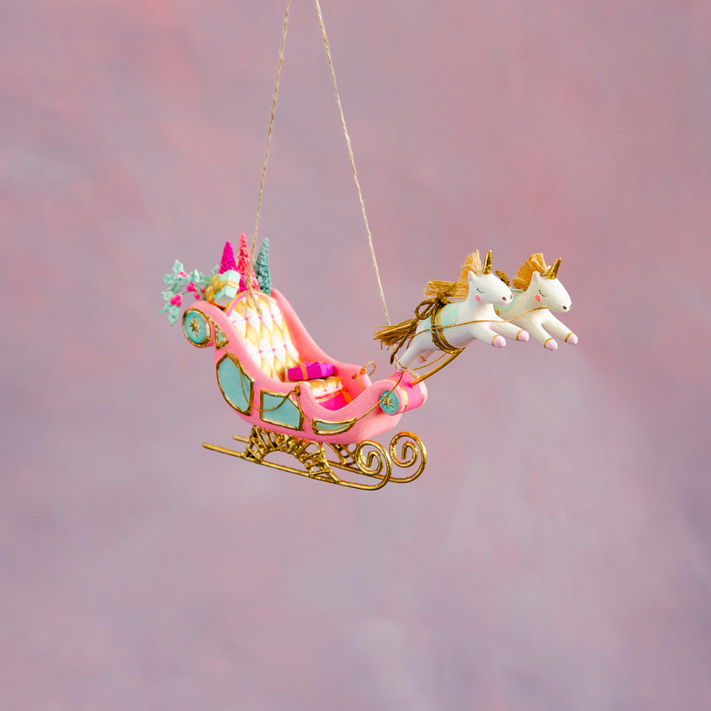 Hand-painted pink Parisian sleigh ornament with gold leafing and two unicorns pulling it.