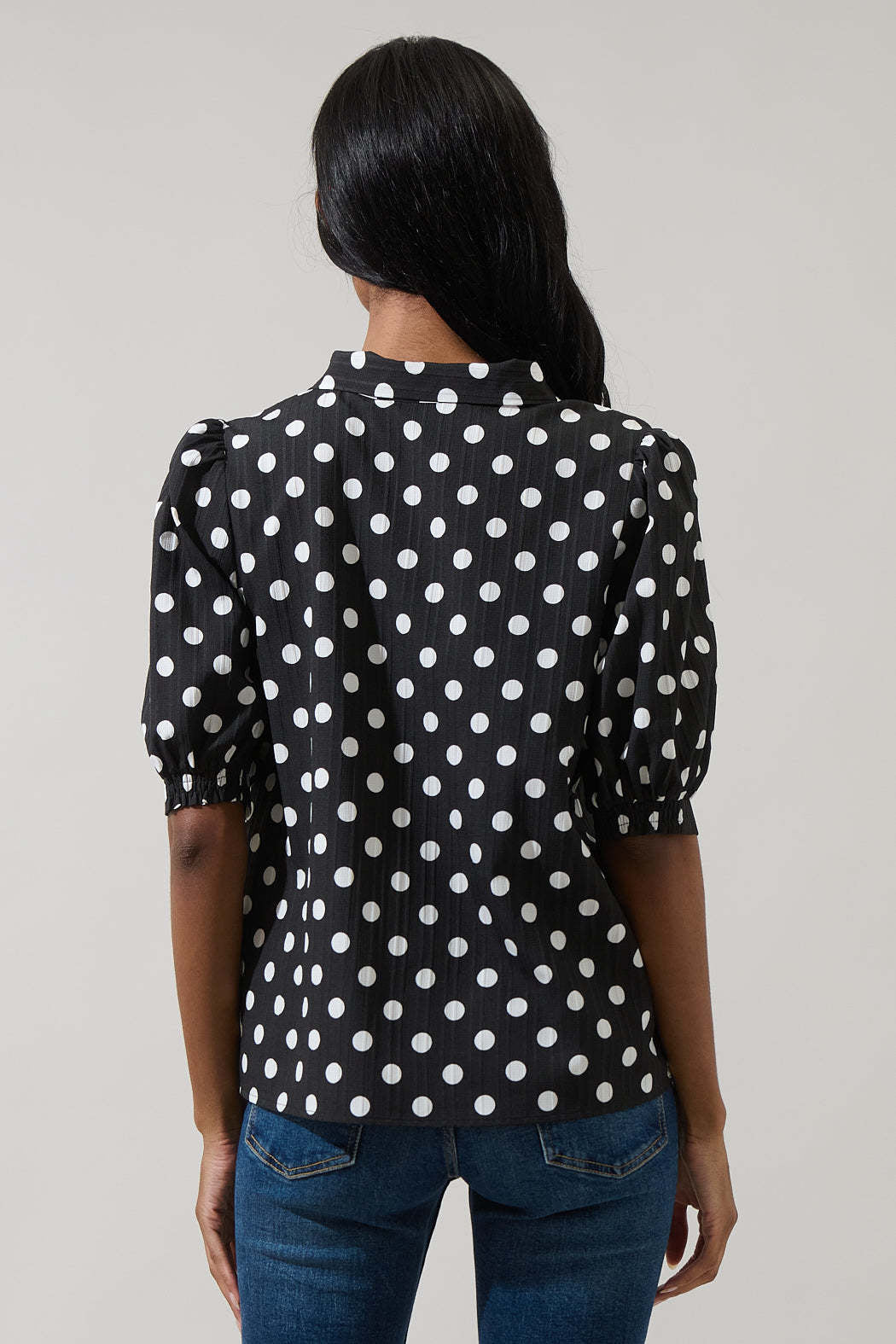 Black polka dot button-down blouse with tie neck and short puff sleeves