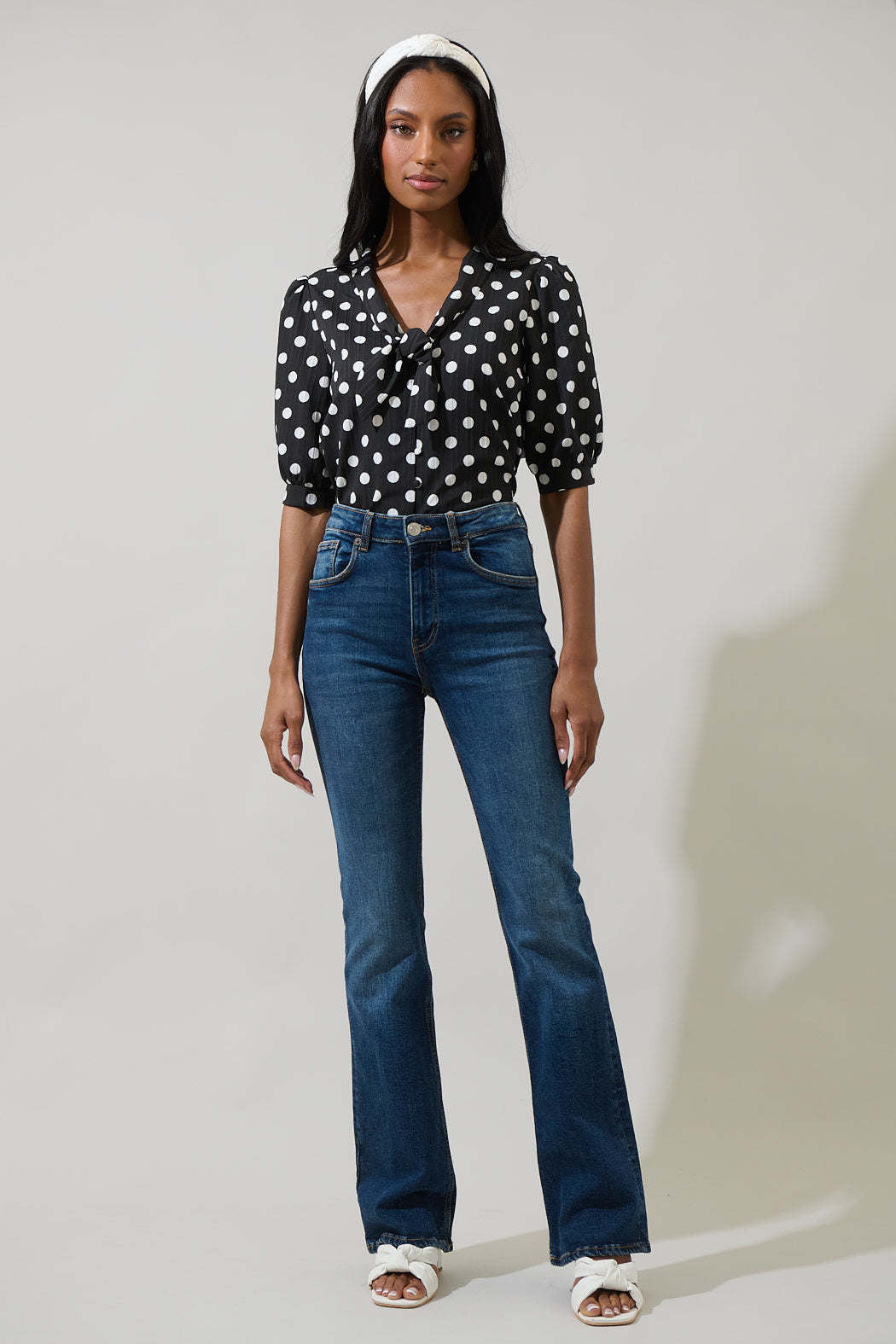 Black polka dot button-down blouse with tie neck and short puff sleeves