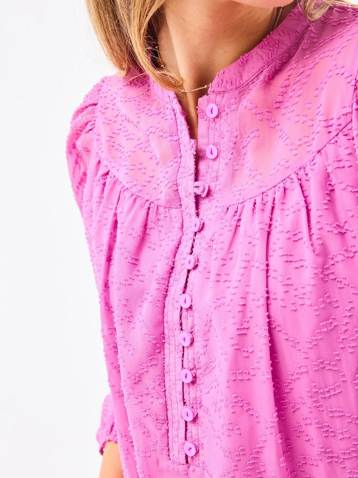 Brianna Top in Crocus featuring lined bodice, button-loop placket closure, and elastic cuffs made from clip dot chiffon polyester.