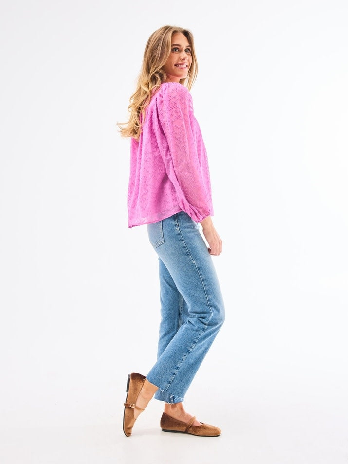 Side view of a lined Brianna Top in crocus clip dot chiffon polyester with button-loop placket and elastic cuffs.