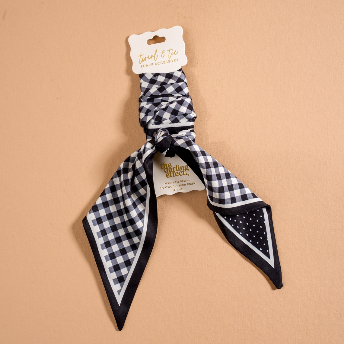 Black and white gingham and polka dot satin scarf accessory on a display card.