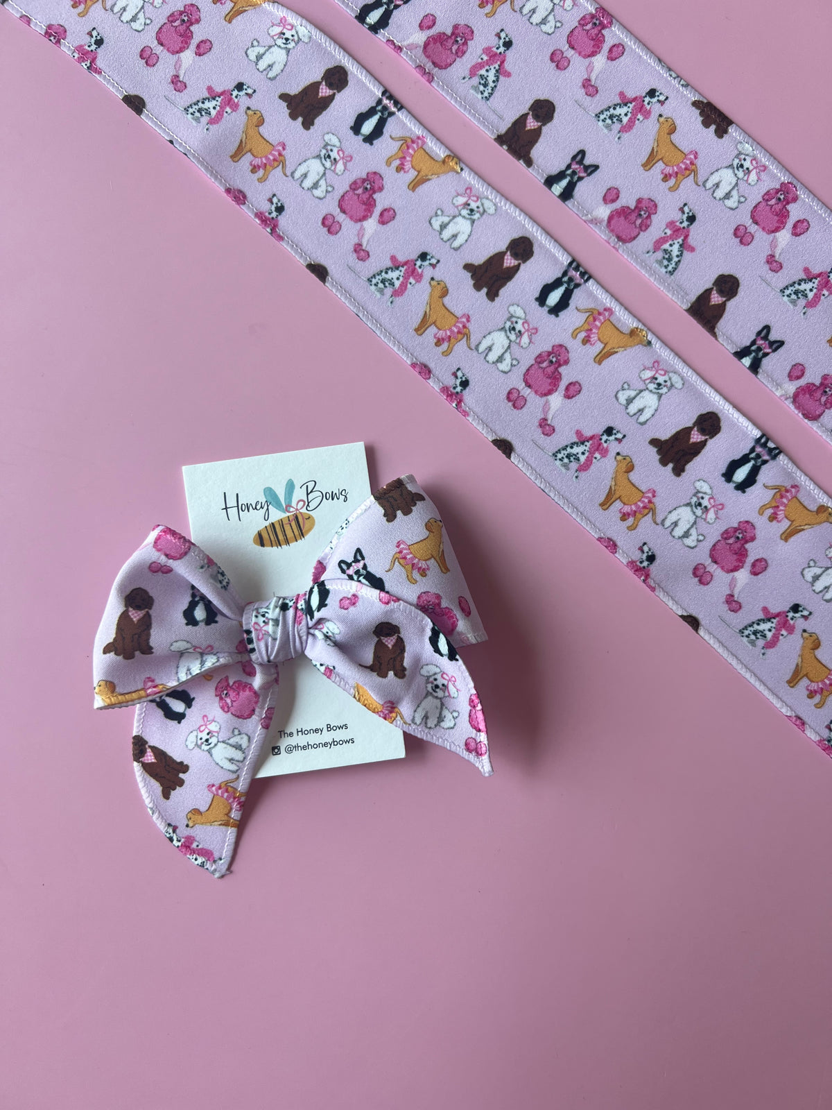 Lavender 4-inch hair bow with a puppy pattern on a clip, shown with matching fabric strips.