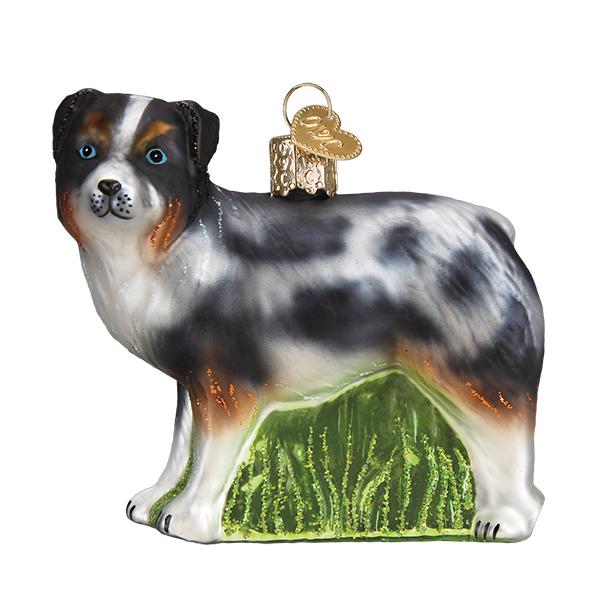 Glass Australian Shepherd Christmas ornament with blue merle coat standing on green grass.
