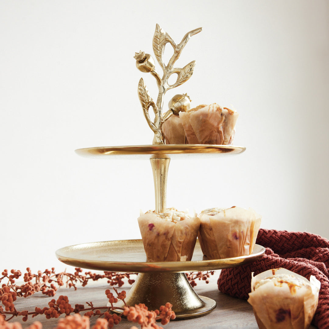 Gold cast aluminum 2-tier tray featuring a pomegranate branch shaped handle with muffins.