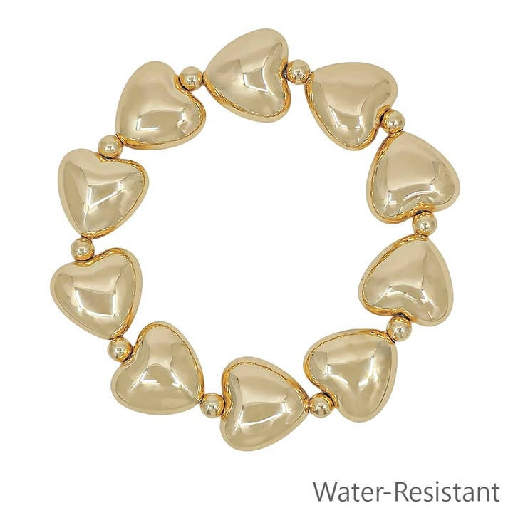 Gold stretch bracelet featuring a large puffy heart charm with water-resistant finish.