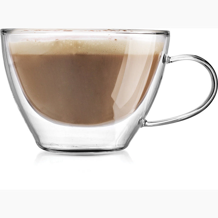 Double wall glass cappuccino cup with handle, filled with coffee and frothed milk.