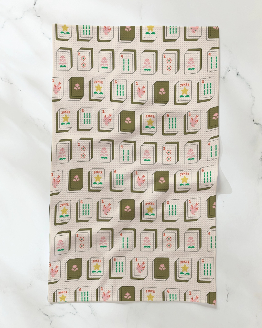 Everyday tea towel featuring a repeating pattern of colorful mahjong tiles on a cream background.
