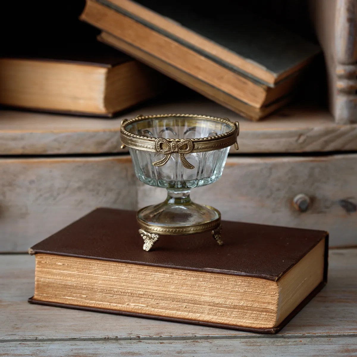 Brass petite urn with a square silhouette measuring approximately four inches tall.