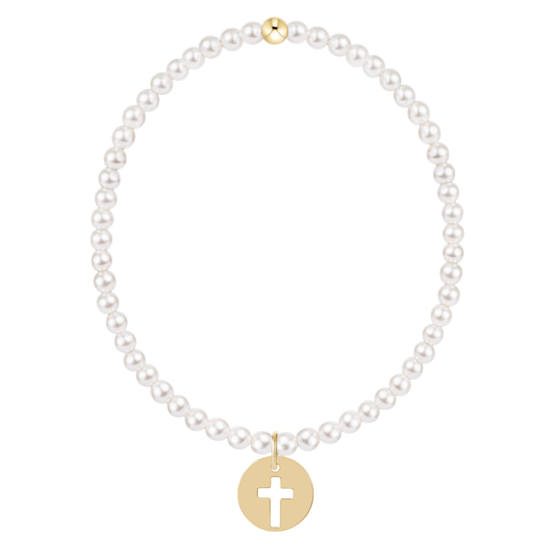 Classic 3mm white pearl bracelet with a gold bead and a gold disc charm featuring a cross cutout.