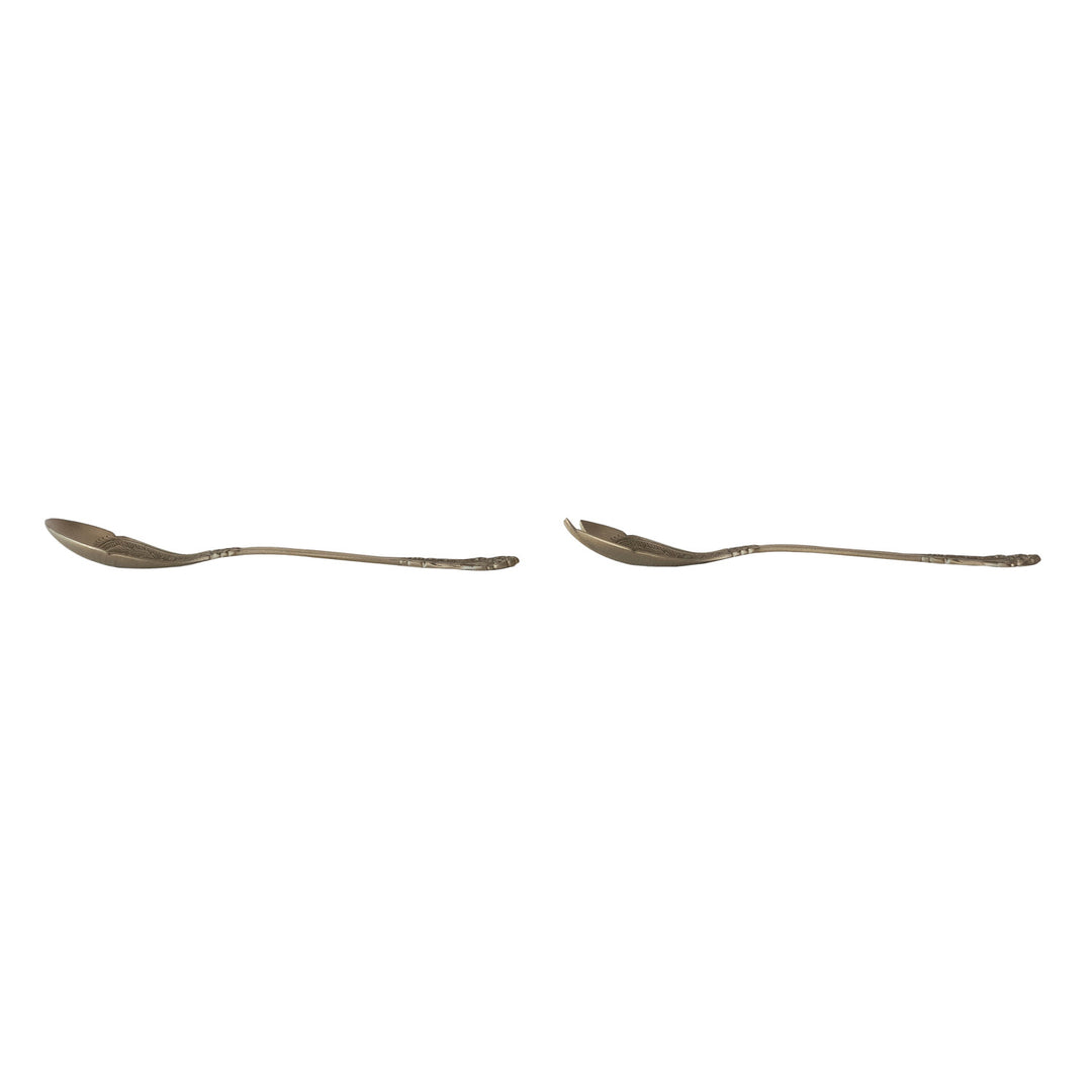 Side view of two embossed brass salad servers, a spoon and a spork, with ornate handles.