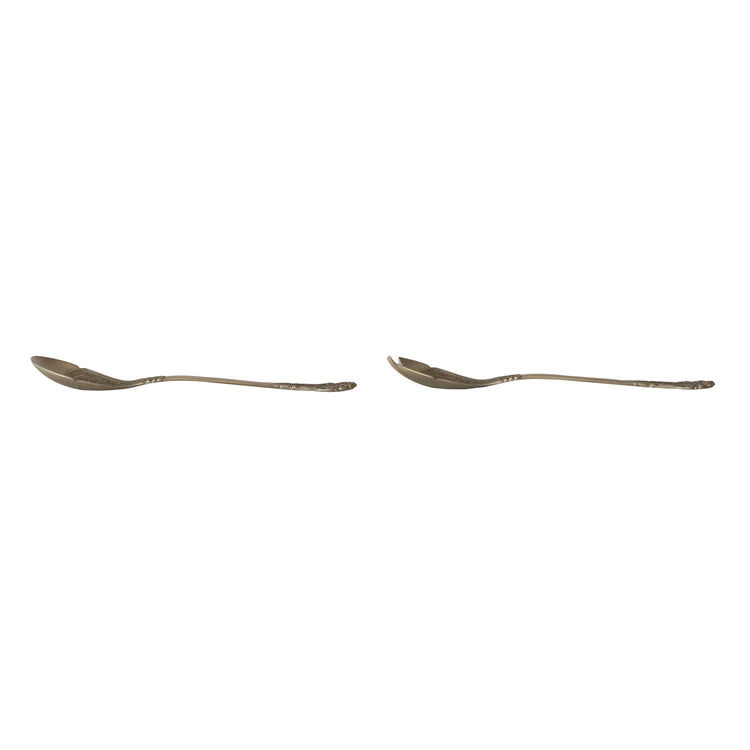 Side view of two embossed brass salad servers, a spoon and a spork, with ornate handles.