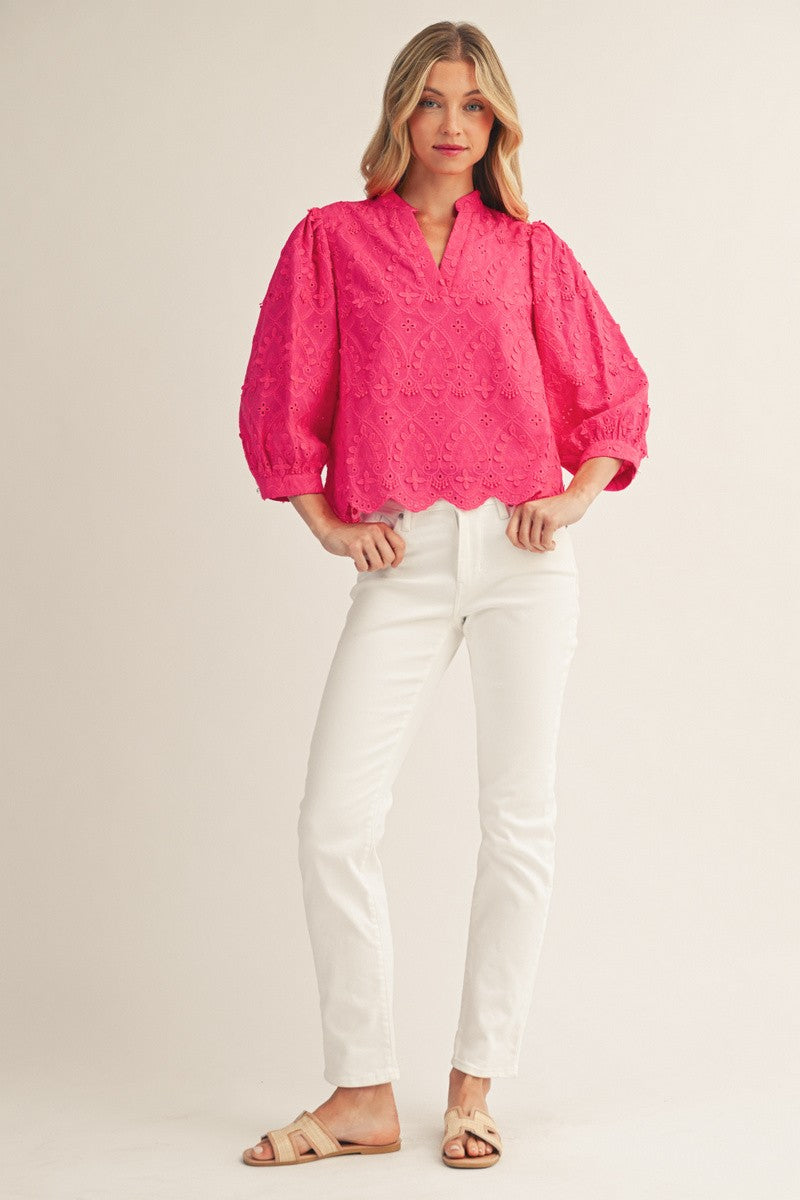 White cotton v-neck top with three-quarter sleeves, scallop hem, and intricate 3D lace pattern.