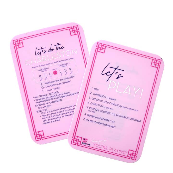Two pink Mahjong tile shufflers with game rules and Charleston instructions printed in white.
