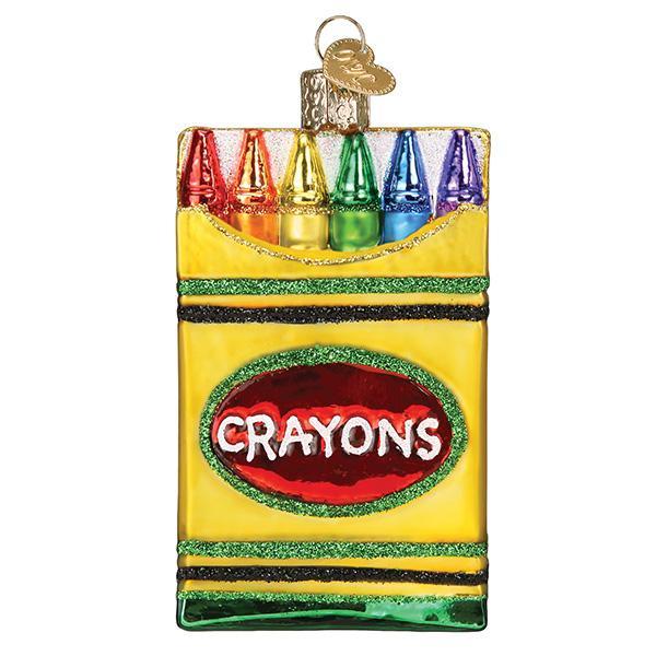 Glass Christmas ornament shaped like a yellow box of six colorful crayons with glitter accents.