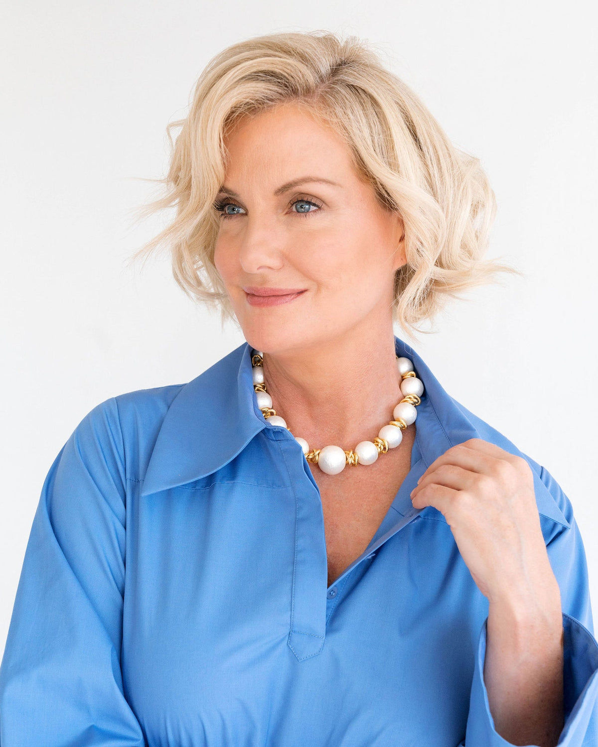 Woman wearing a Cotton Pearl Link Necklace with large white pearls and gold links.