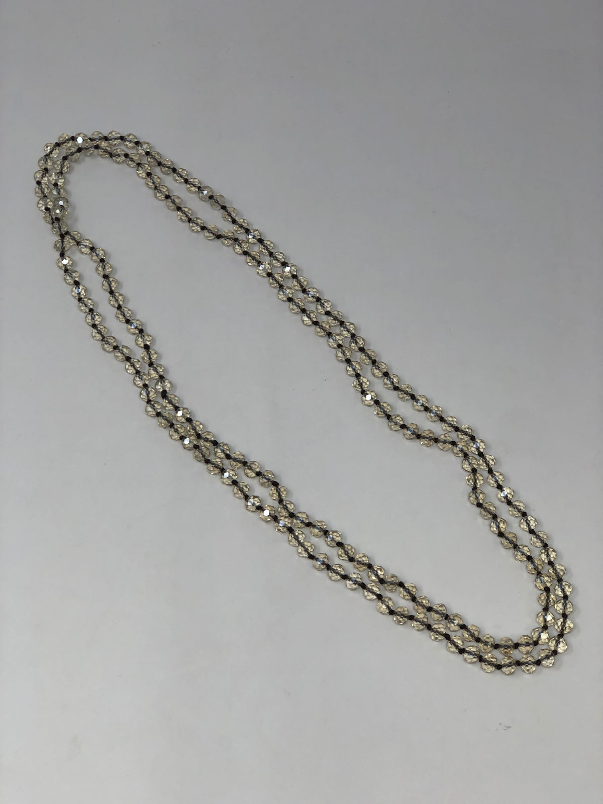 60-inch dark brown crystal beaded necklace with knotting between each bead.