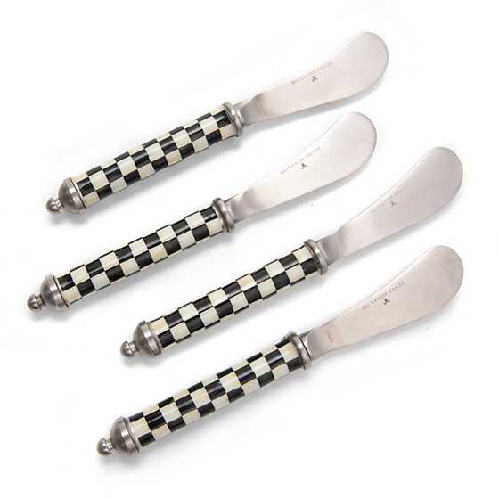 Set of four Supper Club spreaders with stainless steel blades and black and white checkered handles.