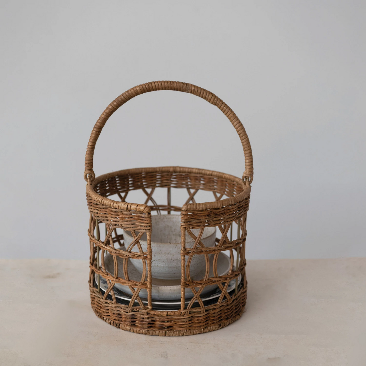 Round hand-woven wicker plate basket with handle in natural brown tones