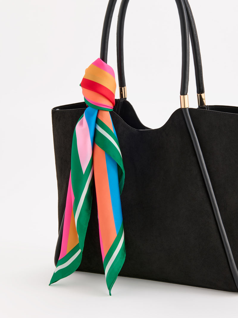 Festive Stripe Square Scarf in multi-color tied to the handle of a black suede tote bag.