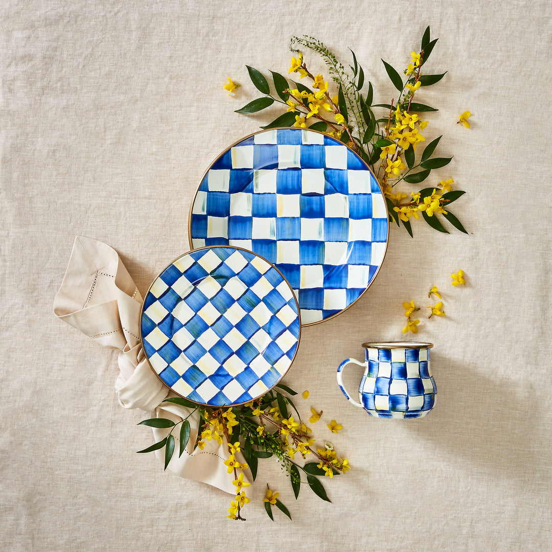 Hand-painted blue and white Royal Check mug alongside matching plates and yellow flowers.
