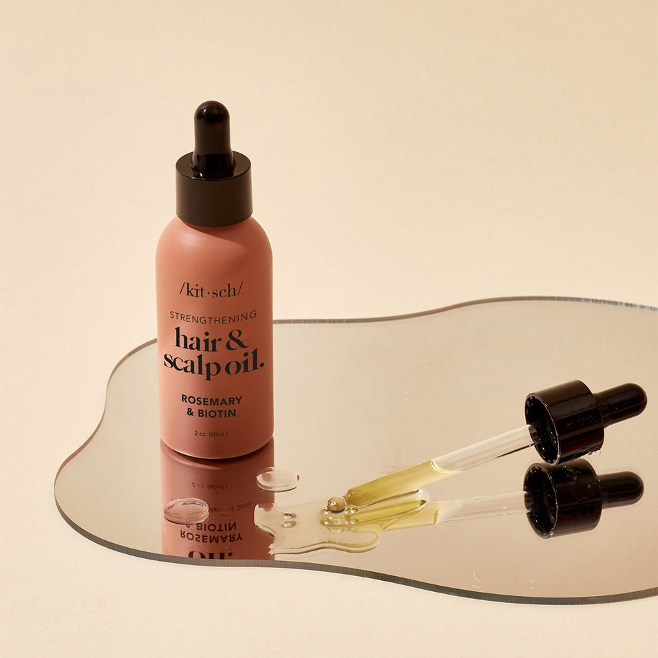 Bottle of Strengthening Hair & Scalp Oil with dropper against white background