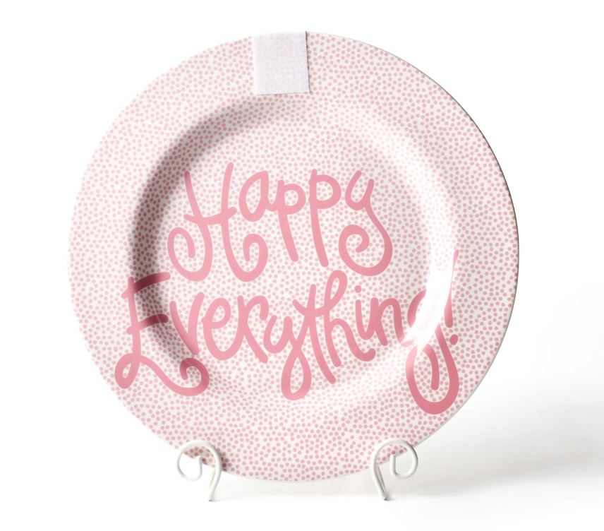 Round ceramic platter in pink with small white dots on a light background.