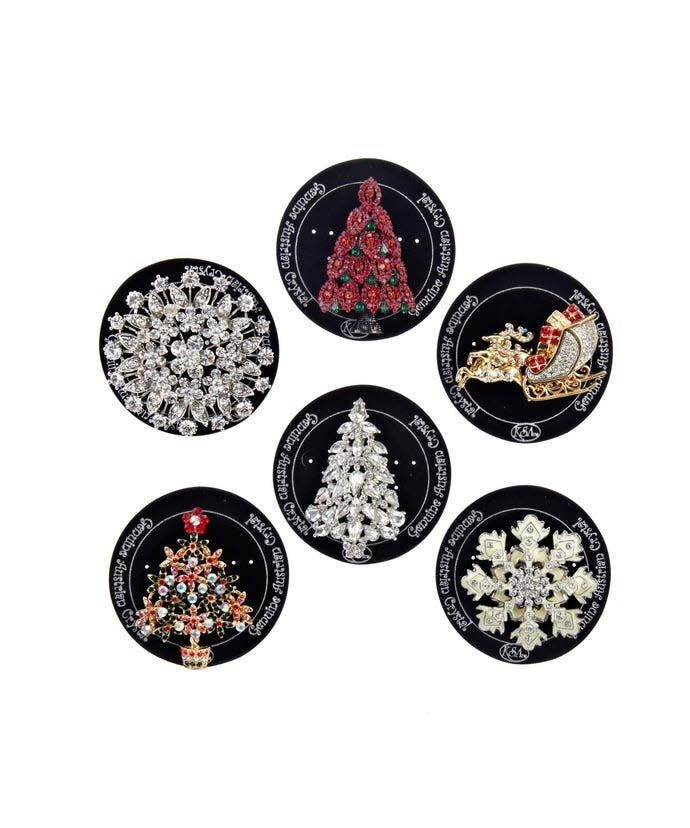 Red Christmas enamel pin with a festive snowflake design on metal backing.
