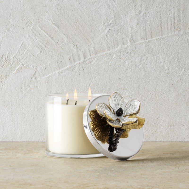 Antique goldtone glass candle holder with oxidized brass accents containing a triple-wick soy wax candle scented with magnolia and jasmine.
