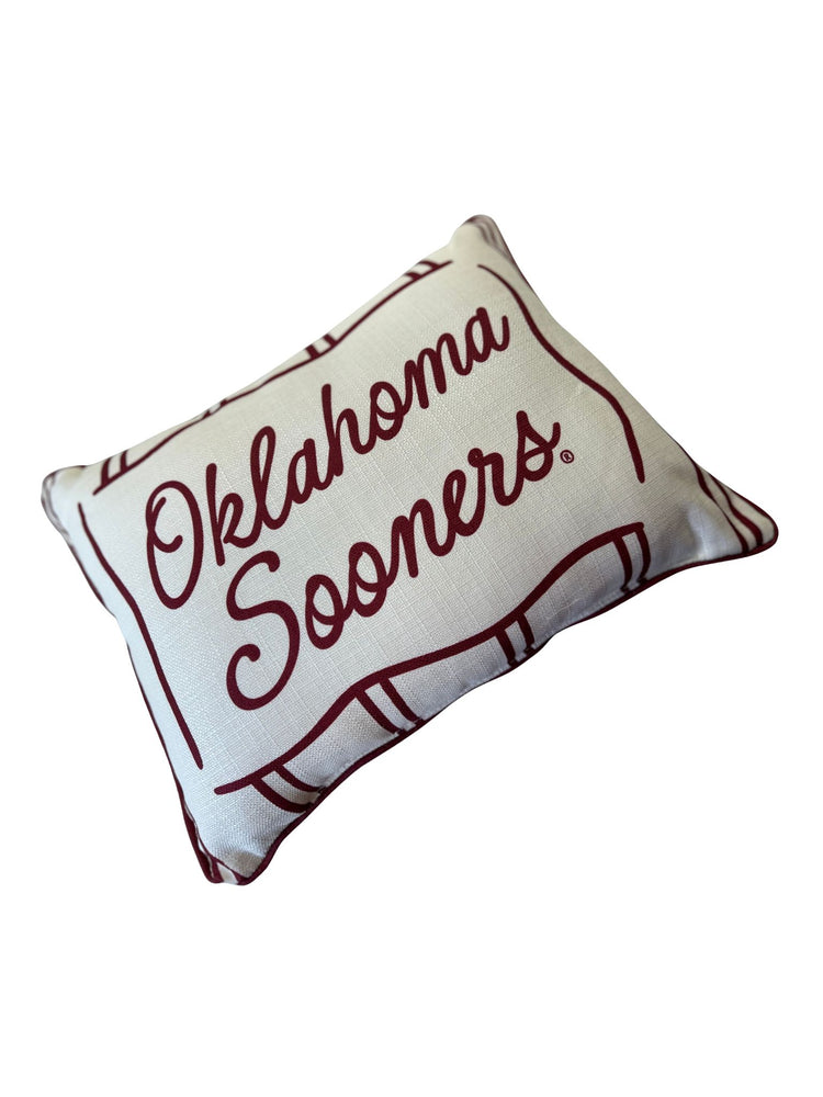 White rectangular pillow with crimson piping and Oklahoma Sooners text in script.