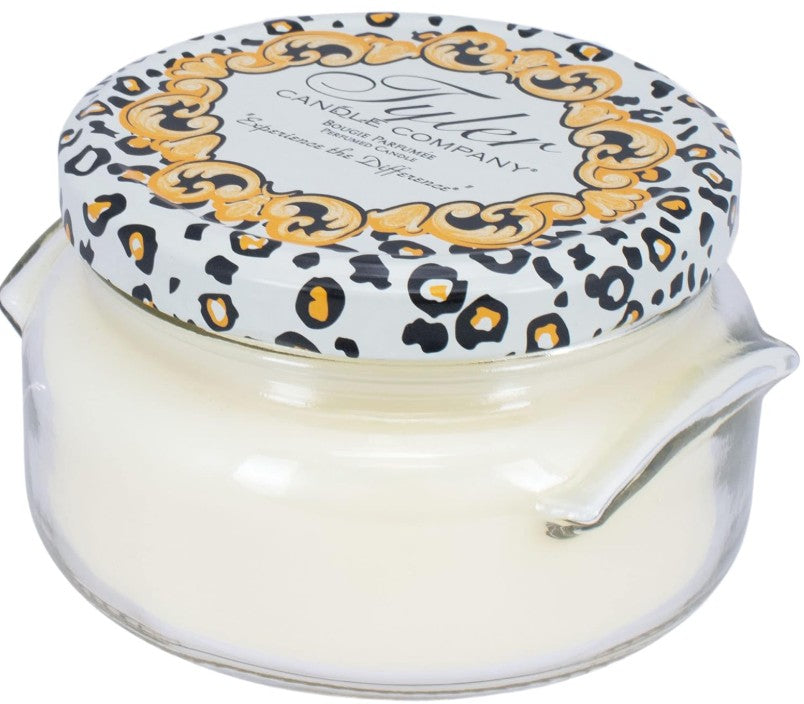 A clear glass jar containing a white candle with the label Tyler Candle.