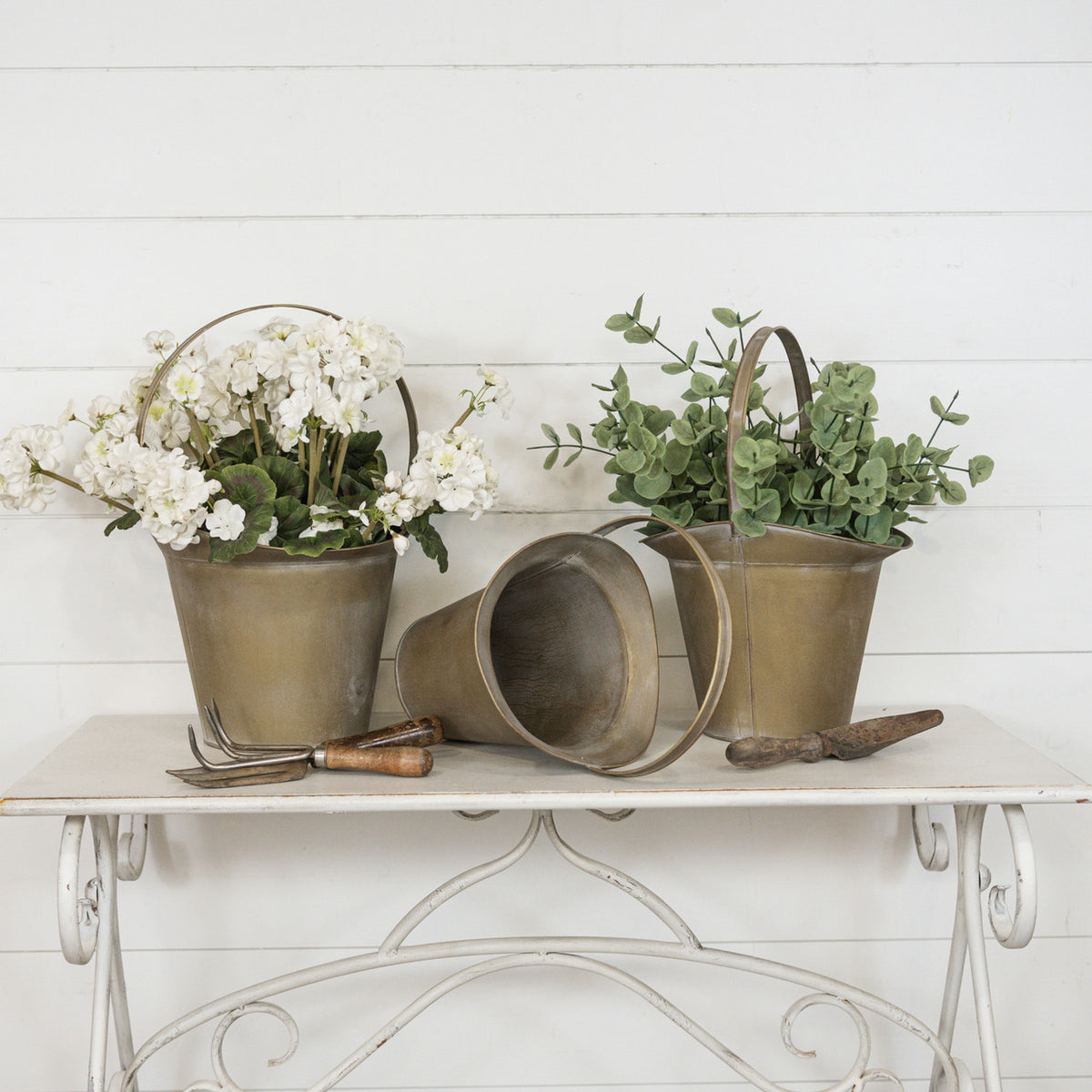 Gold metal slope bucket with a curved handle.